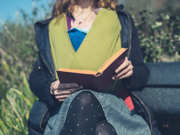 Young Mother Baby Sling Sitting Nature Reading Book — Stock Photo, Image