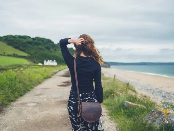 海岸の近くを歩いている若い女性 — ストック写真