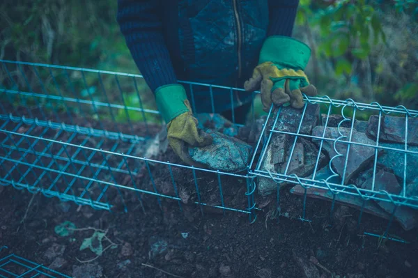 Jardineiro Está Pôr Pedras Num Gabian Aço — Fotografia de Stock