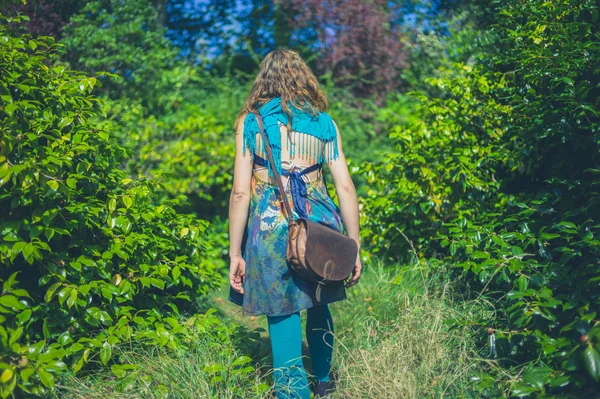 一个穿着不寻常衣服的年轻女子正在森林里散步 — 图库照片