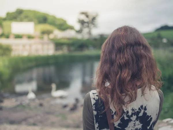 Una Giovane Donna Sta Guardando Uno Stagno — Foto Stock