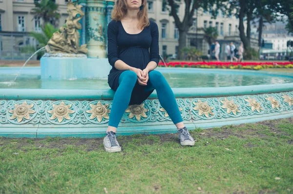 Uma Jovem Mulher Está Sentada Perto Uma Fonte Parque — Fotografia de Stock