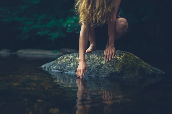 Een Jonge Vrouw Zit Een Rots Rivier Raakt Het Water — Stockfoto