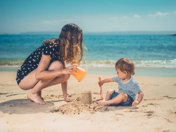 Una Joven Madre Está Jugando Con Hijo Playa Construyendo Castillos — Foto de Stock