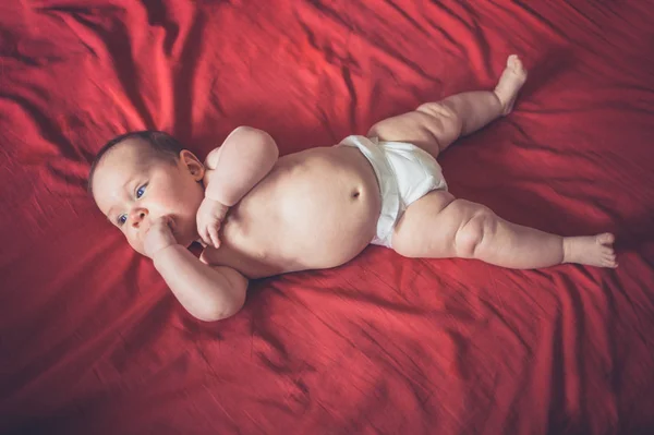 Een Schattige Kleine Baby Zijn Luier Liggend Een Rode Bed — Stockfoto