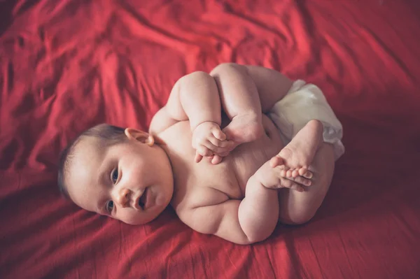 Söt Liten Baby Hans Blöja Liggande Röd Lakan — Stockfoto