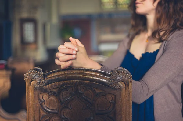 Genç Bir Kadın Ellerini Kavuşturup Kilisede Dua Ediyor — Stok fotoğraf