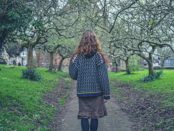 春の公園で若い女性が歩いています — ストック写真