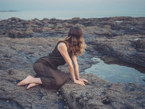 Ung Kvinna Sitter Rock Poolen Kusten Vid Solnedgången — Stockfoto