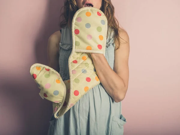 Eine Überraschte Junge Frau Posiert Mit Ofenhandschuhen Vor Rosa Hintergrund — Stockfoto