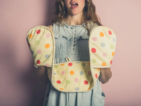 Eine Überraschte Junge Frau Posiert Mit Ofenhandschuhen Vor Rosa Hintergrund — Stockfoto
