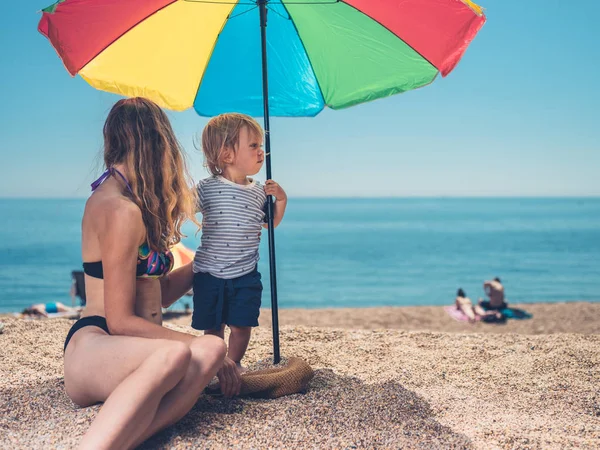 Una Joven Madre Hijo Están Relajando Bajo Una Sombrilla Playa — Foto de Stock