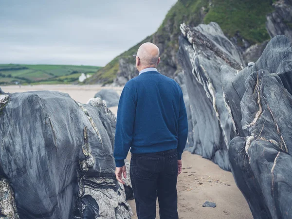 Een Senior Man Het Verkennen Van Een Rotsachtig Strand Een — Stockfoto