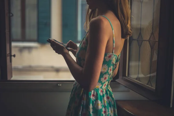 Een Jonge Vrouw Met Behulp Van Een Slimme Telefoon Thuis — Stockfoto