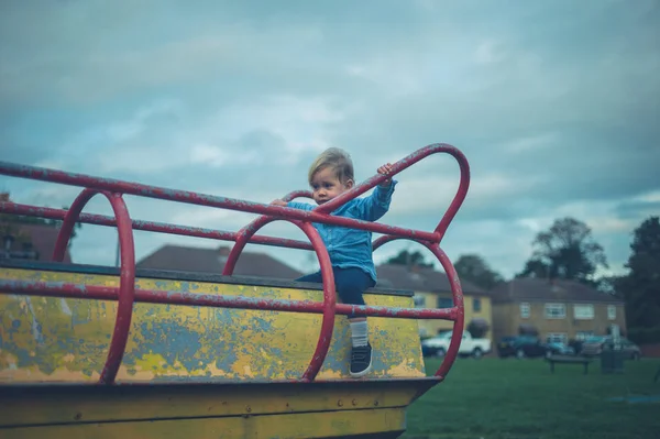 Een Kleine Peuter Zit Speeltoestellen Een Speeltuin — Stockfoto