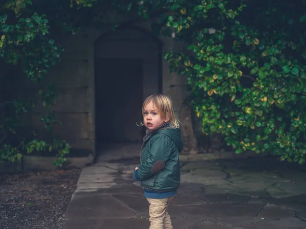 Liten Toddler Står Trädgård Utanför Byggnad — Stockfoto