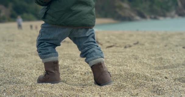 Ένα Χαριτωμένο Αγοράκι Στην Παραλία Είναι Περπάτημα Στη Συνέχεια Πέφτουν — Αρχείο Βίντεο