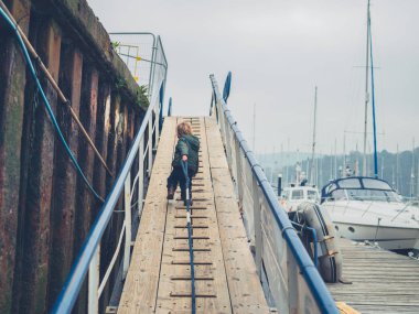 Küçük bir yürümeye başlayan bir Marinada dolaşan ve bir ip çekerek