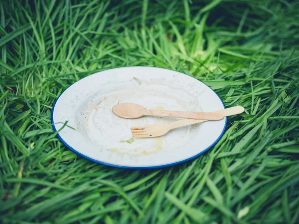 Schmutzige Emaille Platte Mit Holzbesteck Auf Gras — Stockfoto