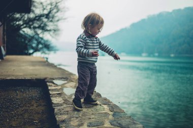 nehir ayakta çizgili jumper giyen küçük yürümeye başlayan çocuk