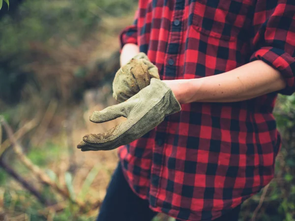 Mujer joven poniéndose guantes de jardinería —  Fotos de Stock