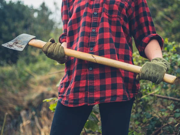 斧を持つ庭の若い女性 — ストック写真