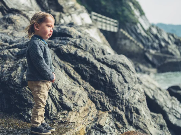 Küçük Bir Çocuk Sahildeki Bazı Kayaların Üzerinde Duruyor — Stok fotoğraf