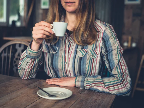 一个年轻女子在咖啡馆里喝浓咖啡 — 图库照片