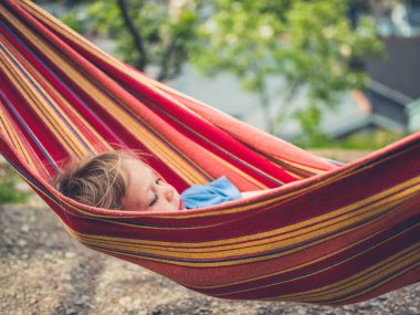 Küçük bir bebek bir hamakta rahatlıyor.