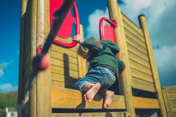 小さな幼児が遊び場に登っている — ストック写真