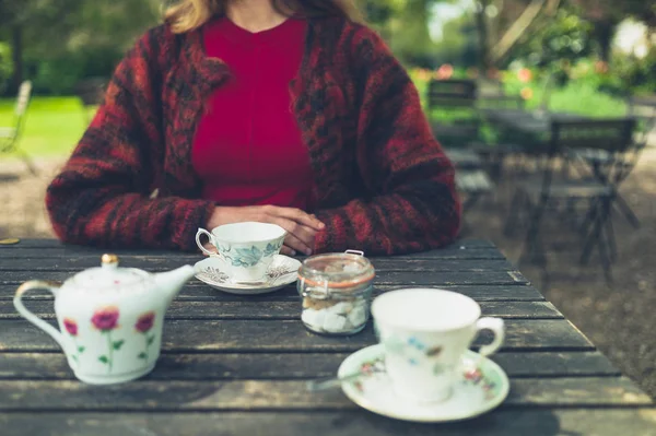 若い女性が公園で屋外でお茶を飲んでいる — ストック写真