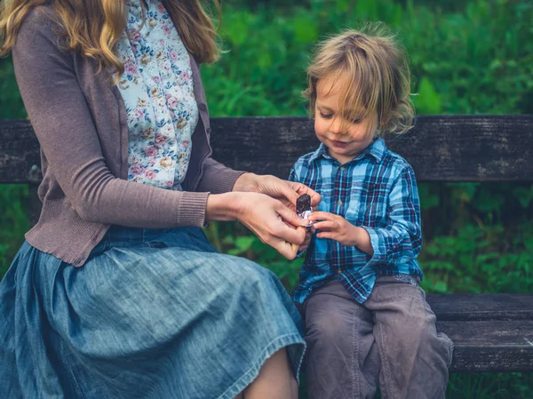 Young Mother Giving Her Toddler Fruit Bar Bench Nature — Stock Photo, Image