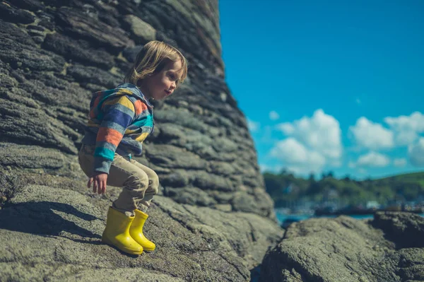 Een Kleine Peuter Staat Rotsen Van Het Strand Een Zonnige — Stockfoto