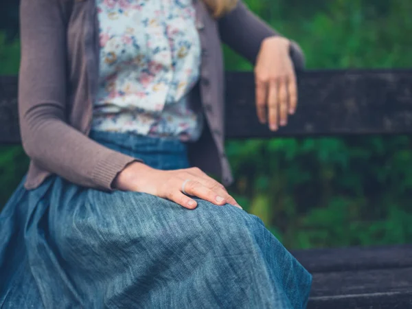 Jeune femme relaxante sur banc dans la nature — Photo