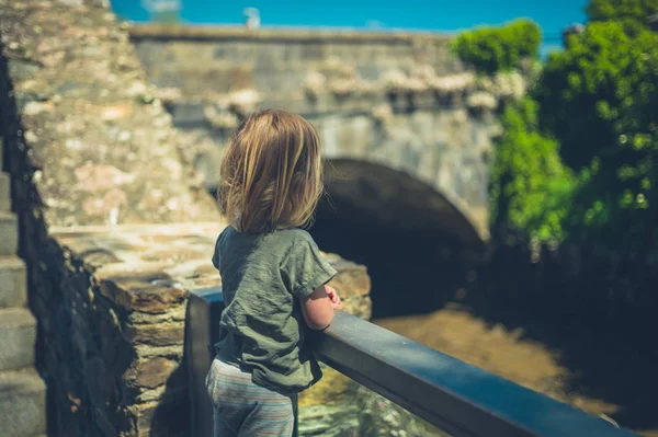 Küçük Bir Çocuk Küçük Bir Kasabada Bir Köprünün Yanında Duruyor — Stok fotoğraf