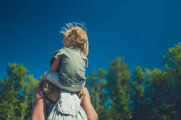 화창한 여름날 아이가 야외에서 어머니의 어깨를 있습니다 — 스톡 사진
