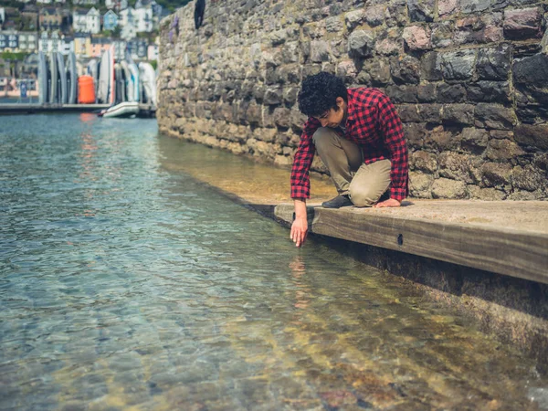 Man relaxing by the water of a marina