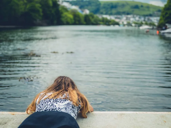 Ung Kvinna Ljuger Vid Flod Och Tittar Vattnet — Stockfoto