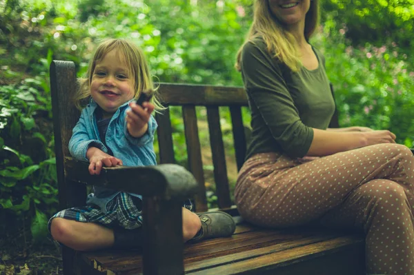 Niño Pequeño Está Comiendo Una Barra Chocolate Con Madre Banco — Foto de Stock