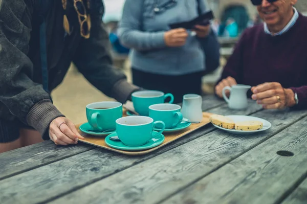 Giovane Donna Posizionare Vassoio Con Tazze Caffè Sul Tavolo — Foto Stock