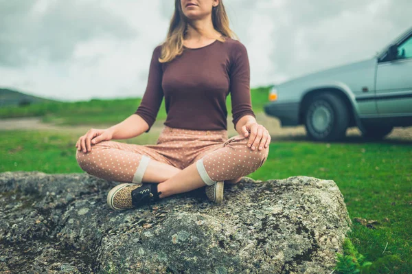 Jonge Vrouw Zittend Meditatie Rots Buurt Van Auto Natuur — Stockfoto