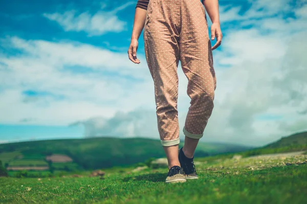 A young woman is walking in the wilderness on a sunny summer day