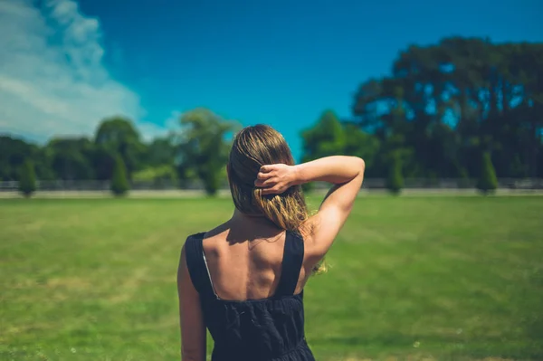 若い女性が晴れた夏の日に公園に立っている — ストック写真