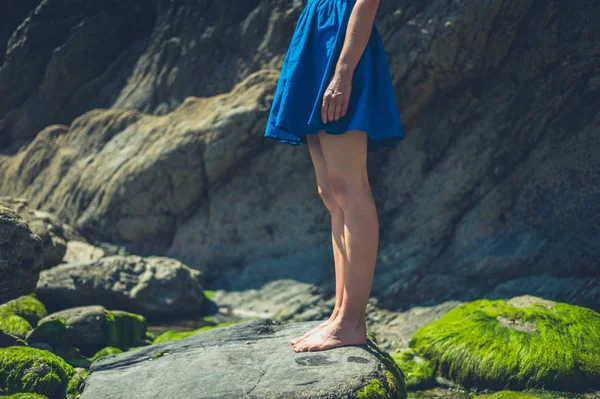 一位年轻女子站在岩石海滩上 — 图库照片