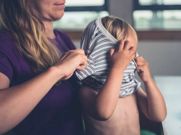Uma Jovem Mãe Está Ajudando Sua Criança Vestir Uma Camisa — Fotografia de Stock