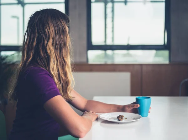 一位年轻女子正在城市公寓里吃早餐和咖啡 — 图库照片