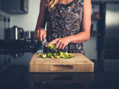 Avokado doğranan genç kadın