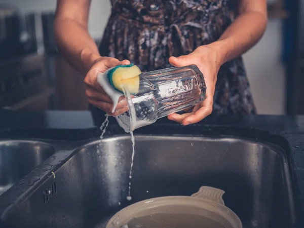 Giovane donna pulire i piatti nella sua cucina — Foto Stock