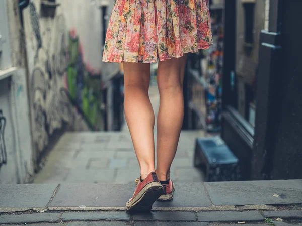 Pernas de uma jovem mulher descendo escadas fora — Fotografia de Stock