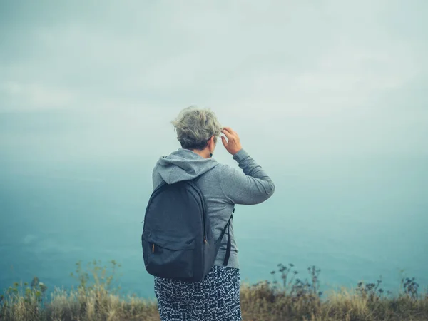 Zpět Pohled Starší Ženy Batohem Při Pohledu Moře Mlhavý Den — Stock fotografie